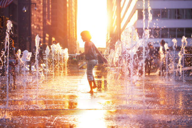 Happy boy run on fountain water Philadelphia city Child run and play on street fountain on Philadelphia square over sunset near city hall in downtown fountain stock pictures, royalty-free photos & images