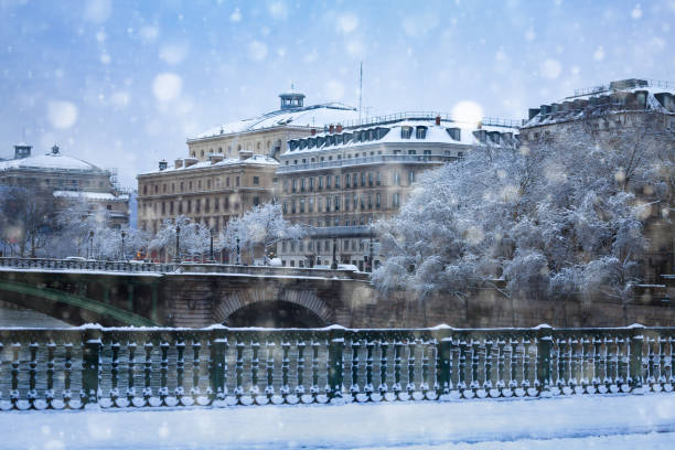 Pont d'Arcole and flooded river banks in Paris downtown with snow covered trees, buildings