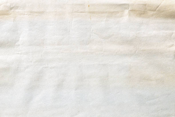 istock Old pale yellow crumpled paper background texture 1210445453