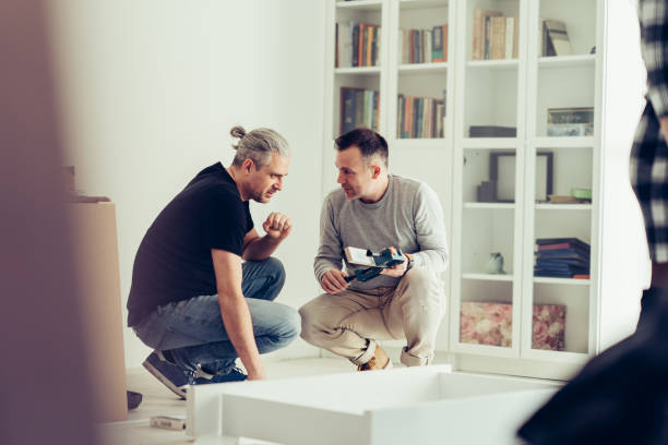 Mature man assembling furniture with his brother.