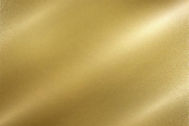 istock Light shining down on gold foil metal wall with copy space, wallpaper background 1210449358