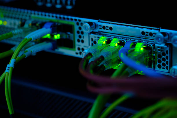 istock Close up UTP CAT6 cable with lighting bokeh and high speed network router switch in a technology data center room. 1210454179