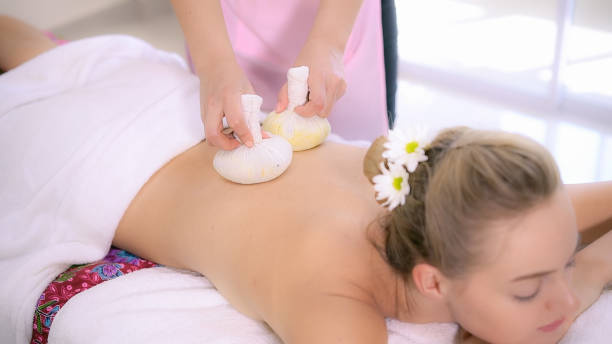 istock Massage therapist using herbal compress with woman 1210456784