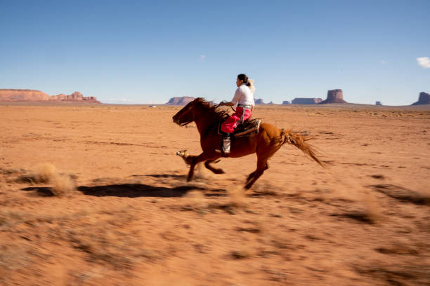 ein junges navajo teenage girl reitpferd in der wüstengegend von monument valley arizona - monument valley navajo mesa monument valley tribal park stock-fotos und bilder