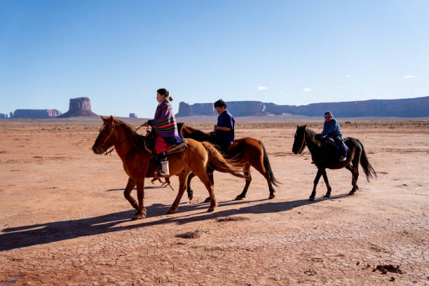 istock Young Navajo Siblings On Their Horses With A Rock Formation Behind Them 1210458786