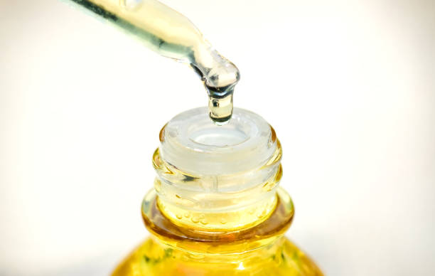 istock Dropping serum collagen moisturizer of face into clear yellow bottle soft light background. Protector skin Treatment facial essence oil, Vitamin C. Beauty and spa Concept 1210458792