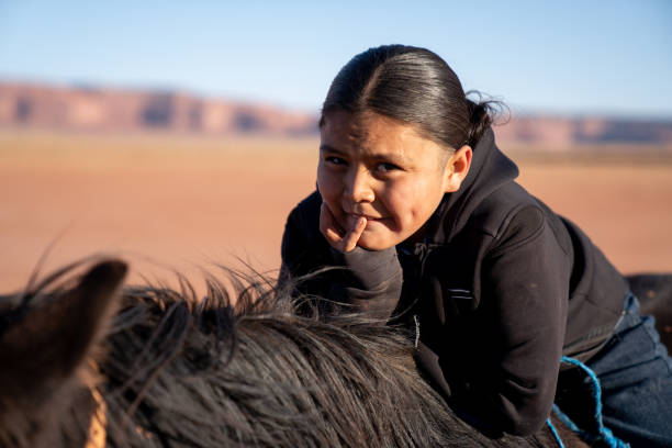 istock A Young Native American Boy, Leaning On Horse, Smiling With Confidence 1210459621