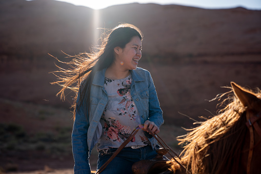 Hermosa joven adolescente Navajo chica nativa americana en su caballo en el norte de Arizona Monument Valley Area photo