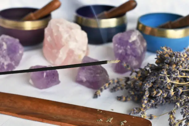 A close up image of burning incense and meditation crystals.