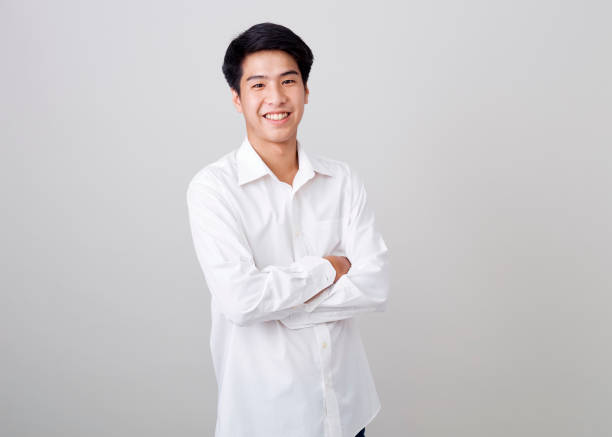 istock young asian handsome businessman on wall over gray background 1210461516