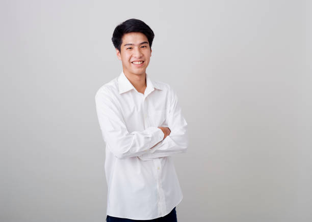 istock young asian handsome businessman on wall over gray background 1210461524