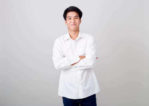 istock young asian handsome businessman on wall over gray background 1210461525