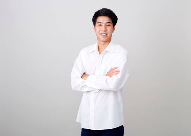 istock young asian handsome businessman on wall over gray background 1210461526