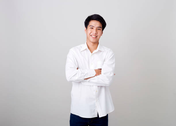 istock young asian handsome businessman on wall over gray background 1210461532