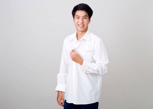 istock young asian handsome businessman on wall over gray background 1210461538