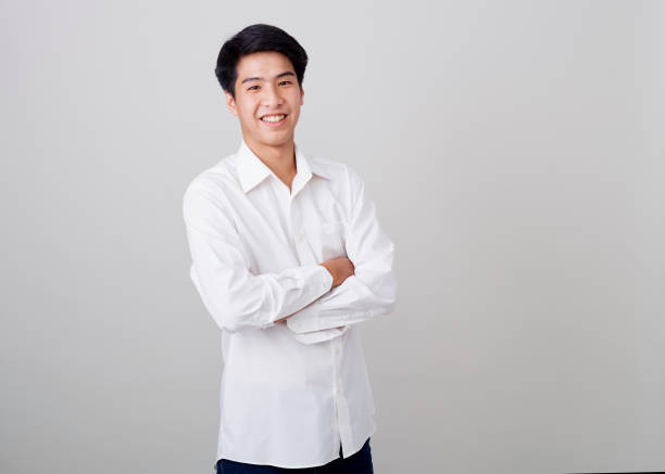 istock young asian handsome businessman on wall over gray background 1210461544