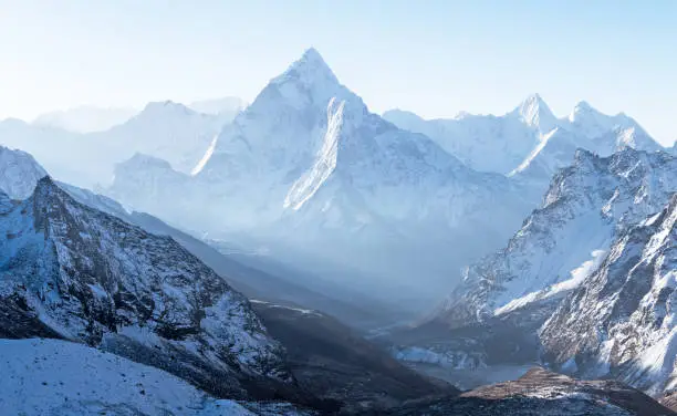 Majestic blue mountain ridges in the morning light; delightful pyramid of Ama Dablam peak (6814 m) in Nepal, Himalayas