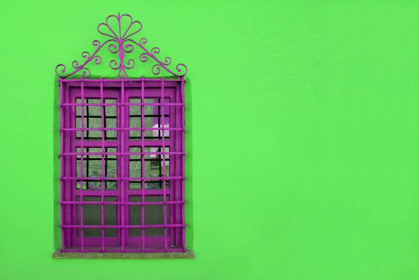 istock Vibrant Purple Wrought Iron Window on Vivid Lime Green Wall 1210473443