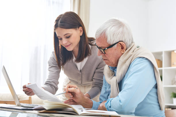 istock Assisting senior man to pay bills 1210473798
