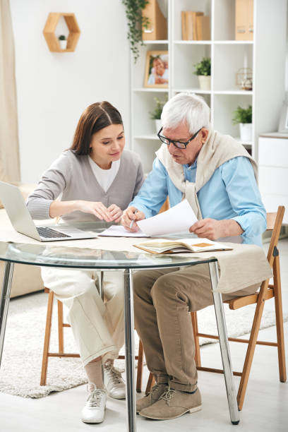 istock Insurance agent assisting senior to fill papers 1210473831