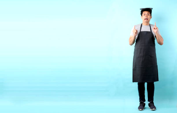 Dining concept. Asian man waiter holding an empty plate.isolated on blue background in studio With copy space.
