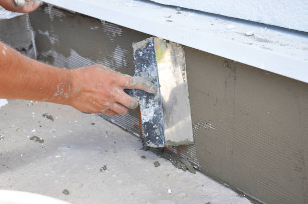 istock Builder is plastering a house foundation wall with a spatula. 1210477387