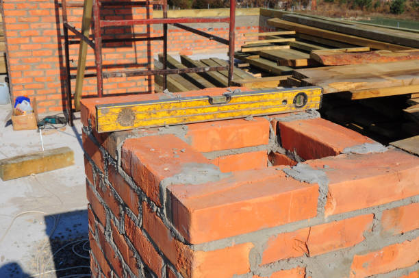 istock Building a brick chimney on a new house construction. 1210477867