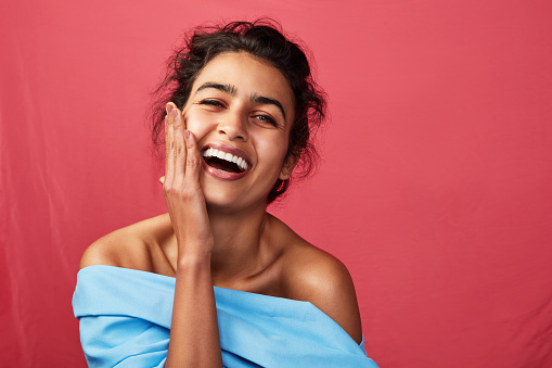 Shot of a beautiful young woman posing against a red background