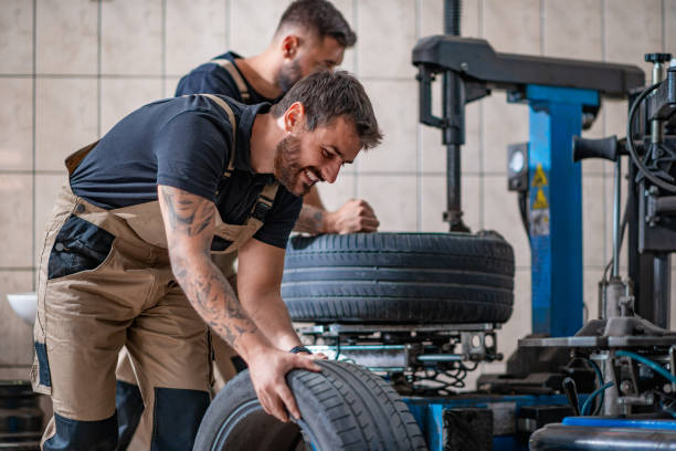 istock Two mechanics in uniform are working in auto service 1210484029