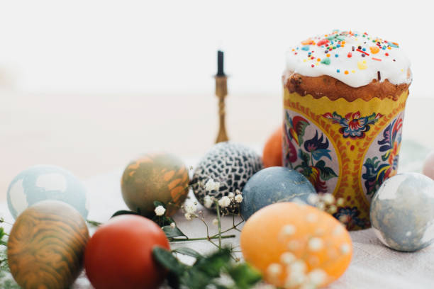 istock Homemade easter cake and stylish easter eggs natural dyed on rustic cloth with flowers and green brunches on table in light. Happy Easter. Traditional Easter bread. Copy space 1210485660