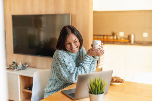 istock Smiling woman with laptop at home office 1210487178
