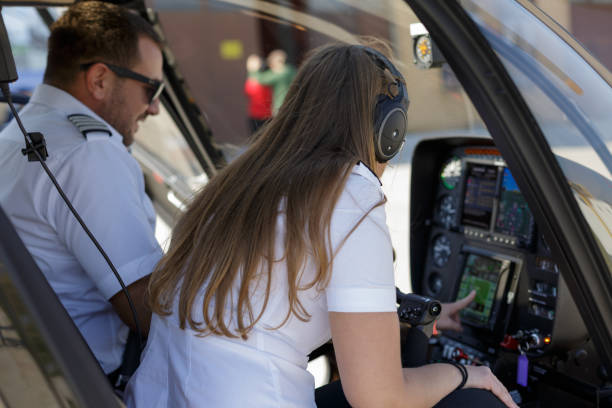 비행 전에 대시 보드 설정을 확인하는 여성 동료와 헬리콥터 조종사 - cockpit helicopter aerospace industry dashboard 뉴스 사진 이미지