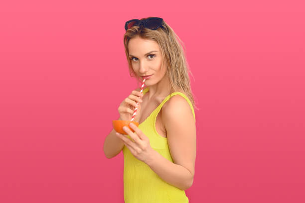 istock Woman drinking through a straw from an orange 1210491490