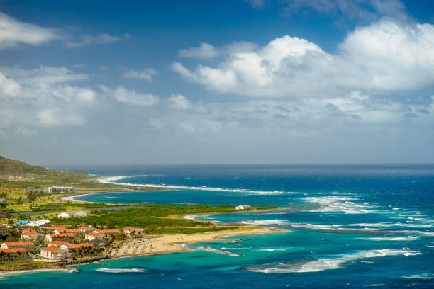 A view over St. Kitts Island with residential area and beaces on the foreground and lush green hills on the background A view over St. Kitts Island with residential area and beaces on the foreground and lush green hills on the background. west indies stock pictures, royalty-free photos & images