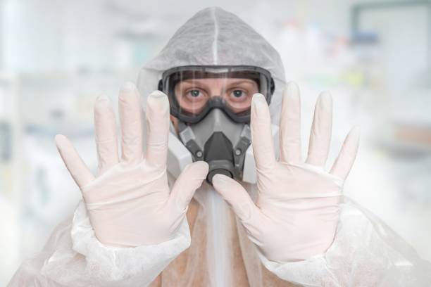 istock Scientist with FFP3 respirator mask is showing STOP gesture 1210493861