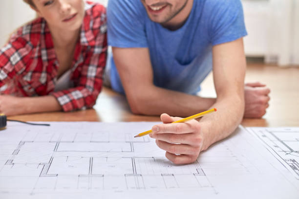 istock smiling couple looking at blueprint at home 1210494253