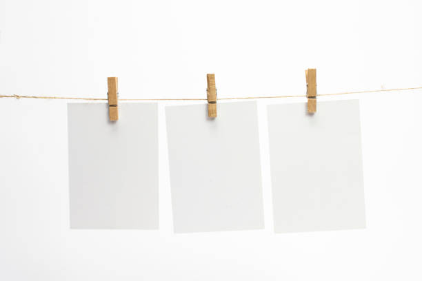 istock Empty blank paper frames that hang on a rope with clothespins and on white background with selective focus. 1210494289