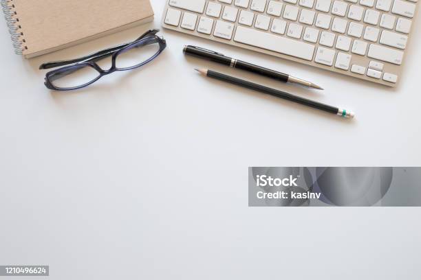 Top View Of Workspace With Computer Keyboard And Office Supplies On White Desk With Copy Space Stock Photo - Download Image Now