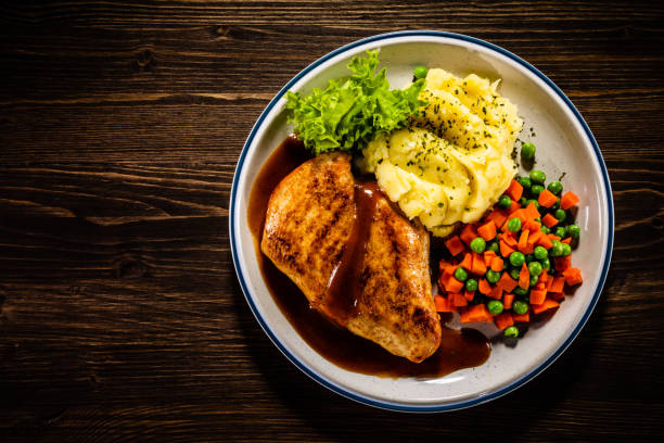 Fried chicken breast and vegetables on wooden background Barbecue chicken breast and vegetables on wooden background chicken fried steak stock pictures, royalty-free photos & images