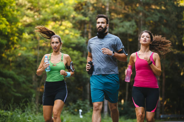 istock Friends jogging together in nature 1210502675
