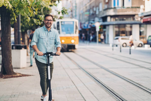 istock Smiling man using electric scooter in the city 1210507348