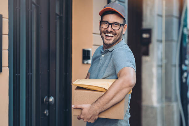 istock Smiling delivery person carrying packages 1210507357