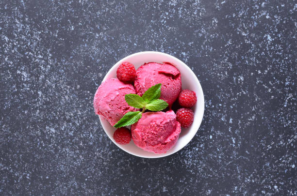 istock Raspberry ice cream scoop with fresh raspberries in bowl 1210507749