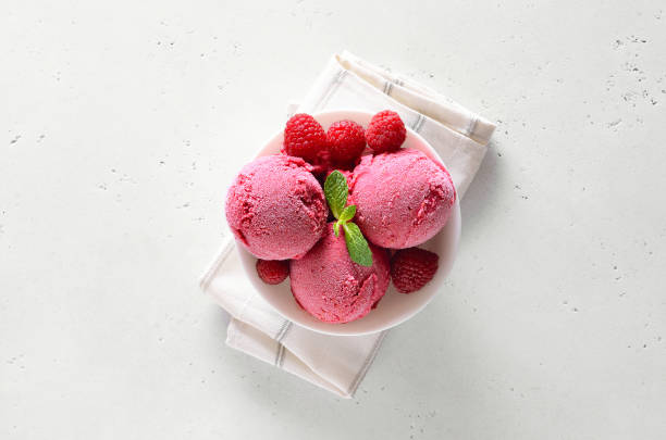 istock Raspberry ice cream scoop with fresh raspberries in bowl 1210507809