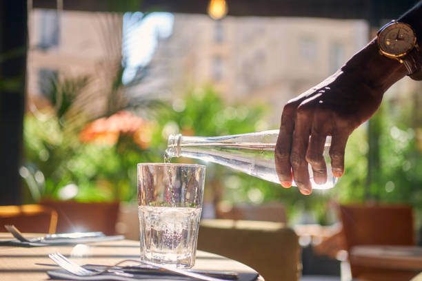 istock Man is pouring water to the glass 1210508854