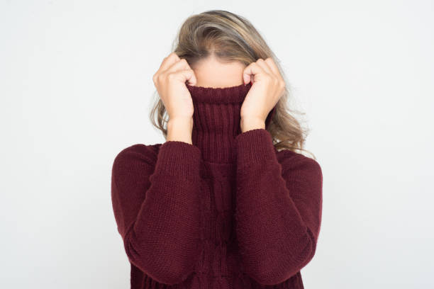 Woman hiding face in turtleneck