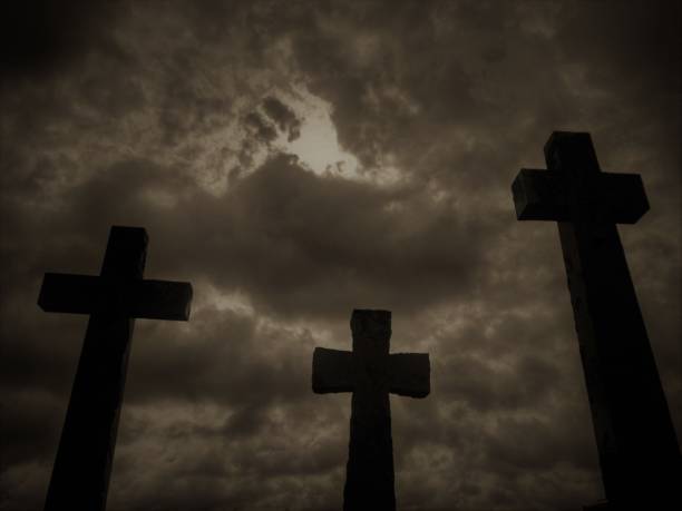 istock Three crucifix tombstones rising against a cloudy sky 1210510871