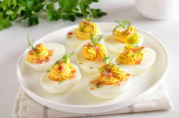 huevos rellenos endiablados con yema de huevo, tocino, mostaza y eneldo - deviled fotografías e imágenes de stock