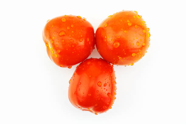 Three fresh red tomatoes with water drops isolated on white background
