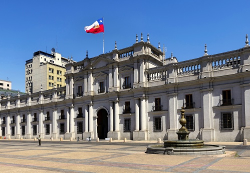 Santiago de Chile, Chile, November 28, 2018: North side of the presidential palace La Moneda on the Plaza de la Constitutión. La Moneda is a neoclassical palace completed in 1805. At the coup d'état of 11 September 1973, the palace was bombed by a military air force and President Salvador Allende shot himself in the encircled building.